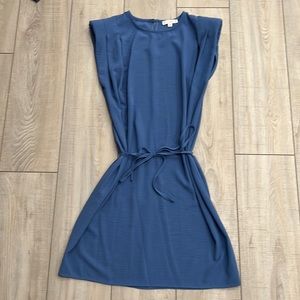 Blue dress. Sewn in shoulder pads. Waist tie and back button closure near neck.